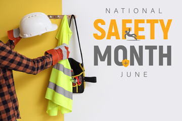 Worker taking safety vest and hardhat from hanger on color wall