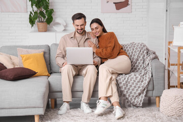 Young couple using laptop at home on autumn day