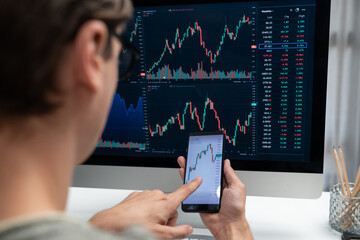 Smart stock investors pointing on screen with smartphone for market stock exchange along with...