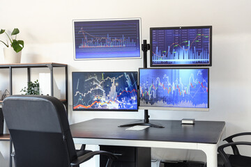 Naklejka premium Computer monitors with stock data on trader's table in office