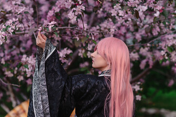 Girl in anime kimono next to pink apple tree