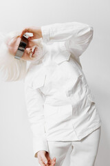 Fashionable model in a white outfit showcasing creativity and style with a metallic accessory...