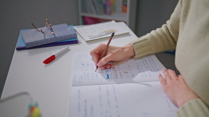 Woman hands checking homework making notes at desk closeup. Educator working