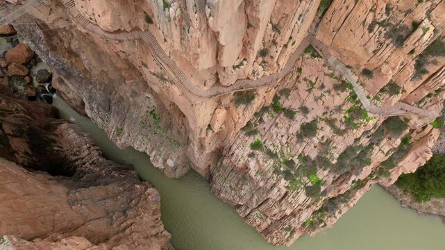 Caminito del Rey in Garganta Gorge, del Chorro, Spain. Aerial shot of a bridge in a narrow gorge, a river flows below. 