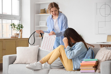 Angry mother with results of school test and belt scolding her daughter at home