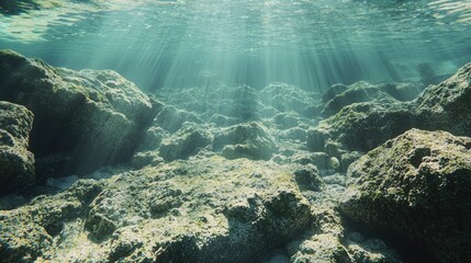 Obraz premium Sunlight piercing through the underwater rocky seabed.