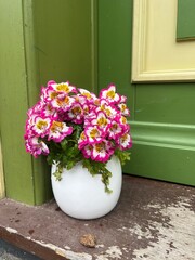Pretty flowers in a small vase on a step outside the front door