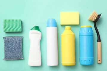 Set of cleaning supplies on green background