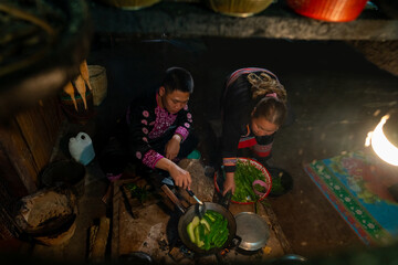 Asian family cooking and having dinner together at home. Hill tribe man and woman in traditional...
