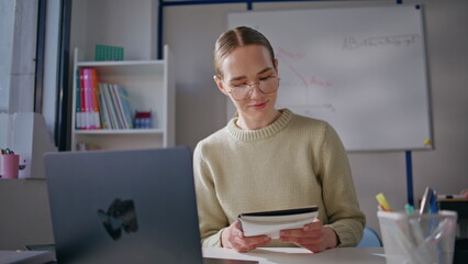 Smart woman conducting online lesson looking laptop screen at classroom closeup