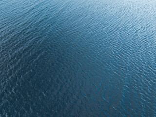 Abstract top view of dark blue water surface with gentle ripples, perfect natural background or...