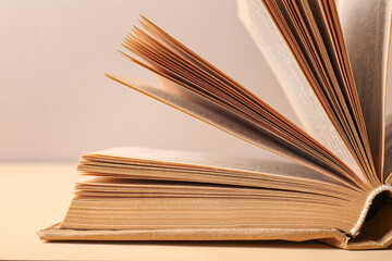Open book on beige background, closeup