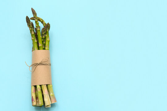 Bunch of fresh green asparagus on blue background