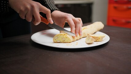 In a Home Kitchen A Hand Cuts Cantucci Biscuits Before Second Baking In Oven