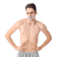 Fototapeta premium Young man with crossed out word FOOD on taped mouth against white background. Anorexia concept