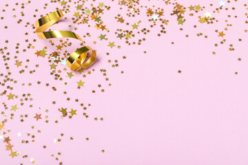 Beautiful golden confetti in shape of star and serpentine on lilac background, closeup
