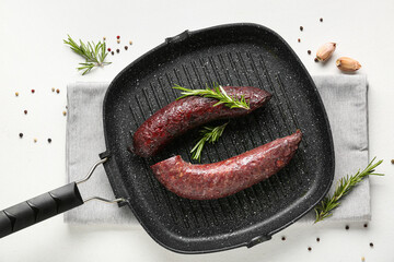 Grill pan with tasty blood sausage on white background, top view