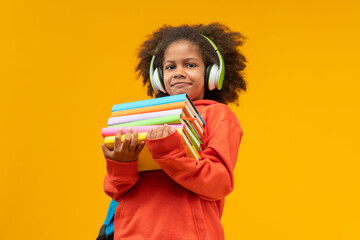 Studio portrait of casually dressed African American girl student wearing headphones and hoodie...