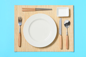 Beautiful table setting with silver cutlery on blue background