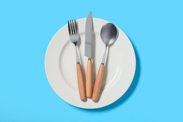 Beautiful table setting with silver cutlery on blue background