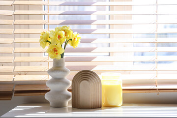 Vase with bouquet of beautiful narcissus flowers on dresser near window, closeup
