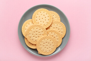 Plate with sweet cookies on pink background