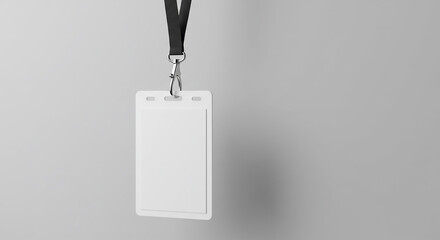 Isolated white id badge hanging from a black lanyard against a plain grey studio background simple minimalist