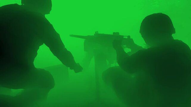 Night vision style infrared video of military personnel operating a mounted automatic machine gun in a tactical setting, emphasizing combat readiness and coordination in low-visibility conditions.

