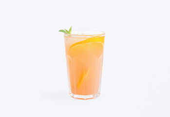 Glass of orange lemonade with mint garnish isolated