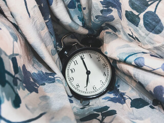 7 o’clock alarm clock with a backdrop of abstract fabric