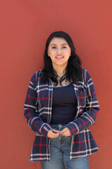 Fototapeta premium A 25-year-old single Latina woman smiles, empowered by having a happy life fulfilled with personal and professional success