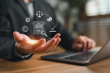 Businessman holding digital legal document icon with law symbols, representing legal technology,...