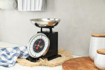 Retro mechanical kitchen scale and other utensils on white countertop indoors