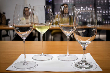 Wine tasting session: four glasses with different amount of white wine on table