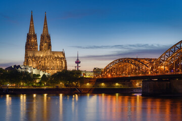 View across the Rhine to Cologne Cathedral with the Ludwig Museum in the foreground and the Hohenzollern Bridge illuminated at dusk