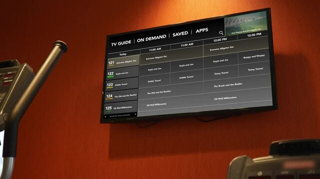 A Wall mounted Tv with generic channel guide in gym.
