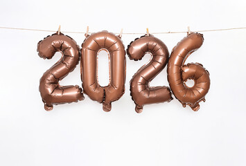 Bronze Metallic Number Balloons 2026 Hanging on String with Clothespins. Celebrating the New Year Party Occasion.