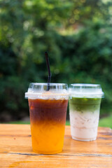Iced Yuzu Americano orange and iced matcha latte green tea on wood table