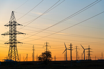 Wind power plants and power transmission lines against the sunset sky