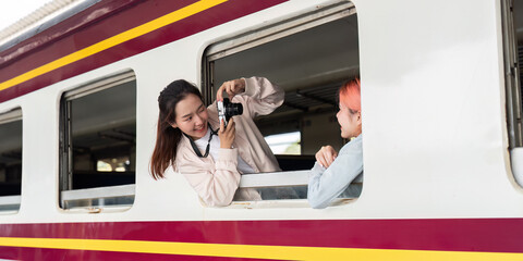 Creativity and Adventure. A traveler capturing memories by photographing her friend from the train.