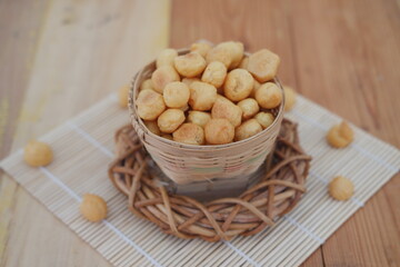  a small woven basket filled with round, golden-brown snacks that appear to be crispy and bite-sized