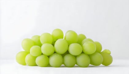 A cluster of light green grapes sits on a white background