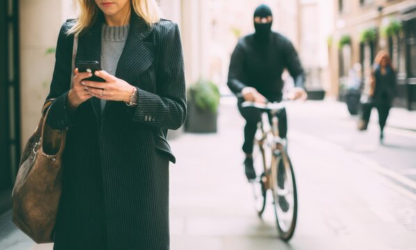 Urban phone snatching threat as woman uses smartphone unaware on busy city street