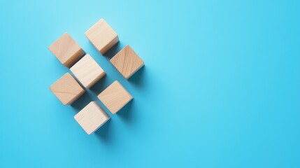 Wooden blocks arranged on bright blue background with copy space.