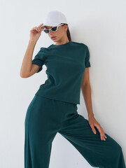 Fashionable model poses elegantly in a modern studio environment with stylish accessories