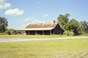 Obraz premium Explore old wooden building with rusted metal roof in countryside field view