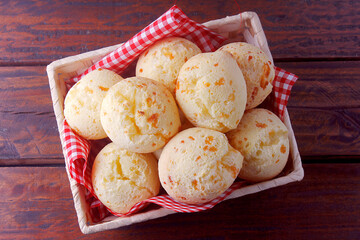 homemade cheese bread, traditional Brazilian snack, in the basket on a rustic kitchen table