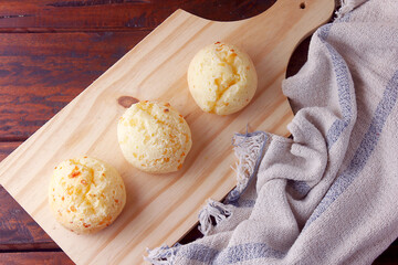 homemade cheese bread, traditional Brazilian snack, in the cutting table on a rustic kitchen table