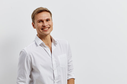 Smiling man in white shirt with AI chat concept use phone standing isolated on light background happy confident young caucasian male digital communication technology