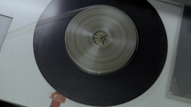 Persona manipulando pel&iacute;cula f&iacute;lmica de 16mm o 35mm en mesa de montaje f&iacute;sico. Cine anal&oacute;gico, moviola, edici&oacute;n tradicional, cinematograf&iacute;a, historia del cine.